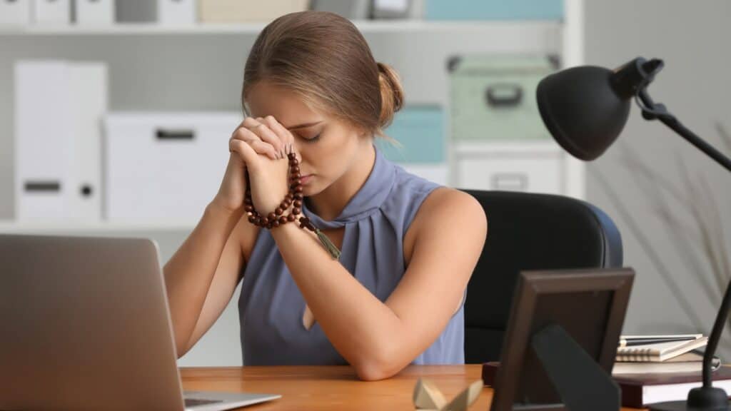 woman sitting at her desk and praying